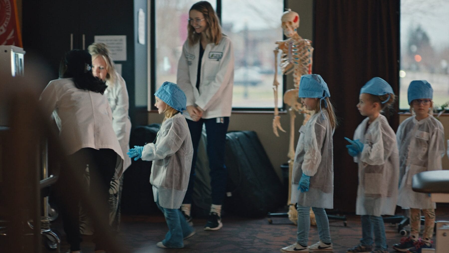 four children dressed like doctors, a skeleton and three college students.